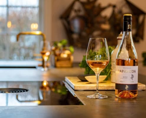 Flaske vin og vin glas på oplyst køkkenbord